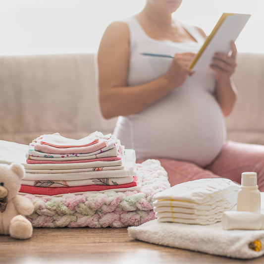 Pregnant woman checking off a baby registry list