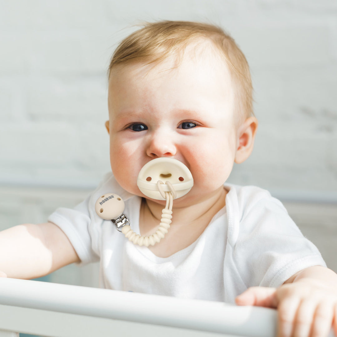 A happy baby with a Haakaa Flexi-Dummy in their mouth