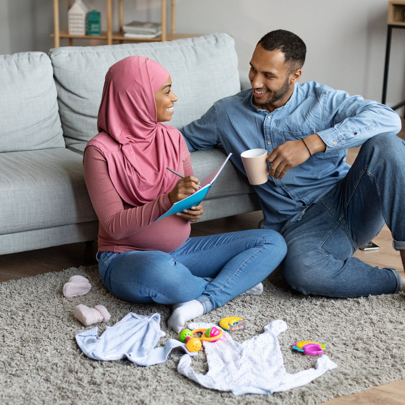 Couple making a checklist of items needed for their soon-to-arrive baby