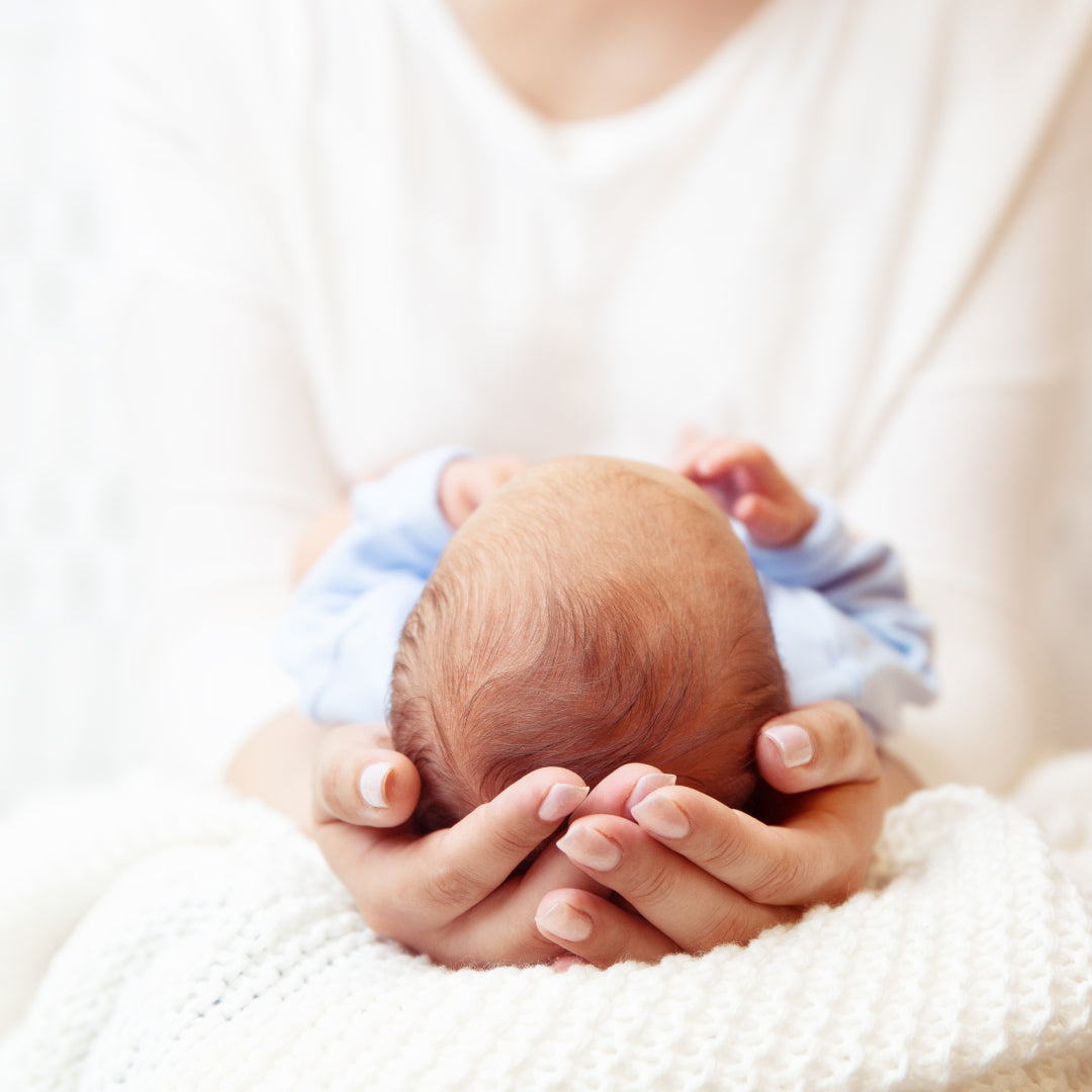 Newborn cradled in mother's hands