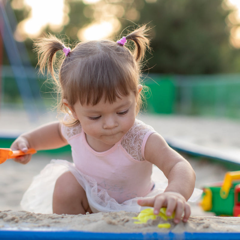 A small girl playing in a sandpit