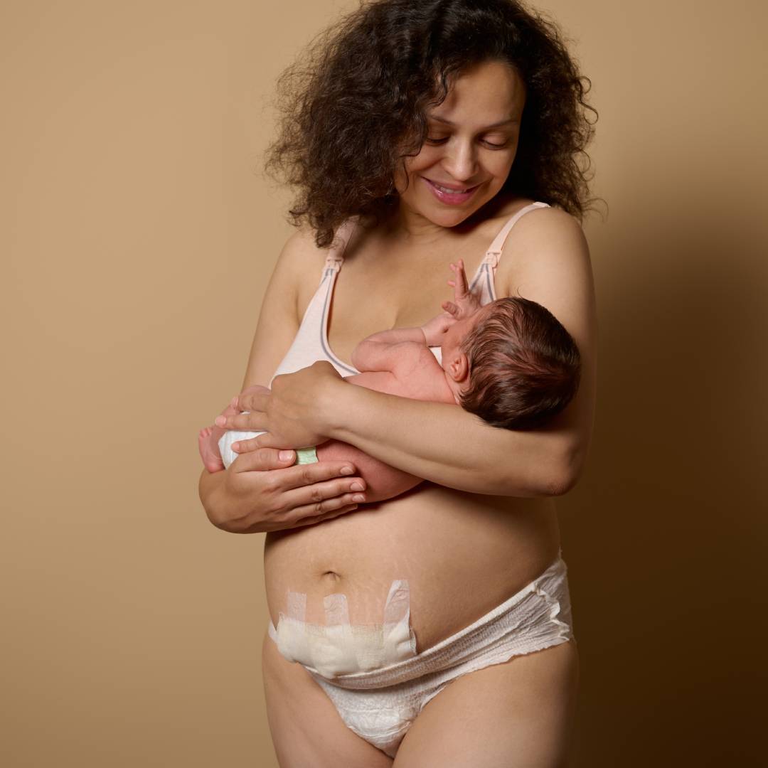 Post-caesarean mum smiling down at her baby